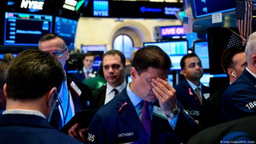 Stock Broker on Wallstreet holds his hands to his face in despair.